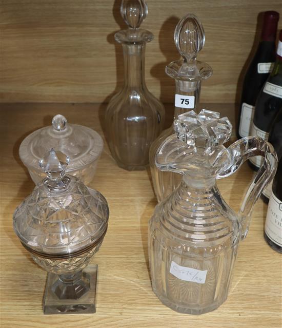 A pair of cut glass decanters, a jug, a silver-mounted Georgian honey jar and cover and later etched honey jar and cover